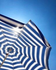A blue and white beach umbrella opened towards the sky. Vacation and sunshine. Antalya, Turkiye. © Serpil