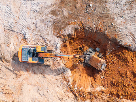 Excavator with hydraulic hammer dismantling a building at a construction site