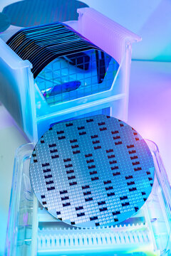 Silicon Wafers in plastic holder box for manufacturing semiconductor of integrated circuit.Electronic circuit designs have been built onto the wafers using micromaching including photolithography