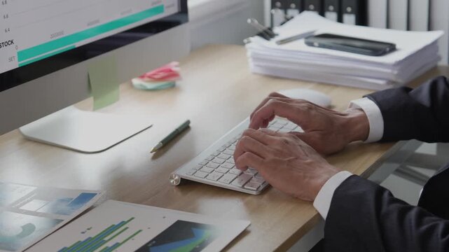 A young professional is examining investment data graphs and charts, analyzing financial information, and monitoring stock market trading reports.