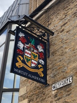 Looking up, at pub sign for Wortley Almshouses on Westgate Peterborough UK. July 2026