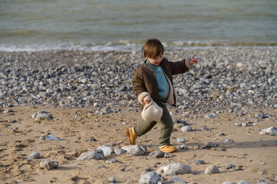 little kid have a fun on a rocky beach