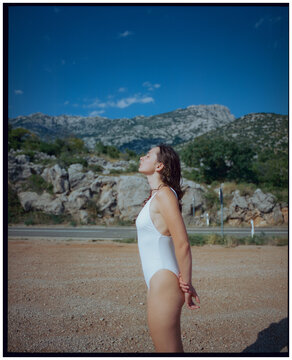 Woman standing on gravel parking after swim, shot on film 
