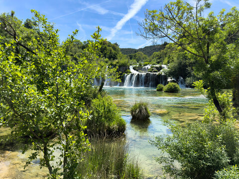Lovely turquoise color waterfalls and cascade mountain river running through the forest during late spring
