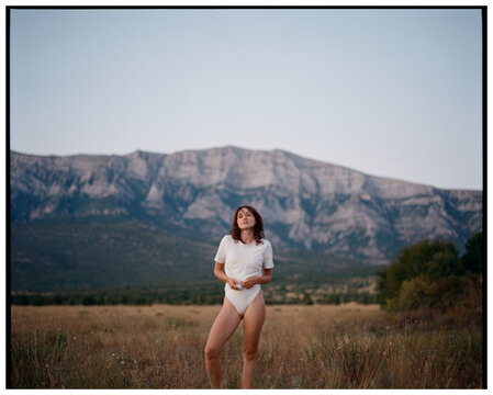 Woman in a wide field in the mountains in Croatia, shot on film 