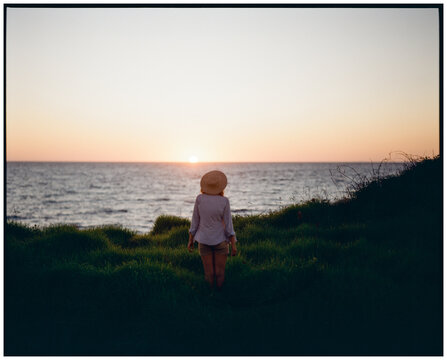 Woman looking at the sunset over the sea id Greece, shot on film 