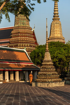 Temple With Large Stupa and Monk Walking on Pathway