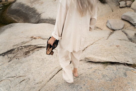 Barefoot Woman Walking Across Coastal Rocks
