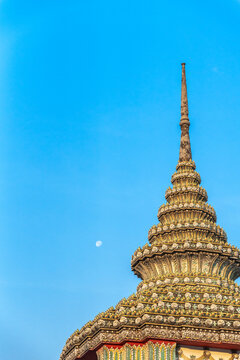 Sky View of a Temple Spire With the Moon and Clear Blue Sky