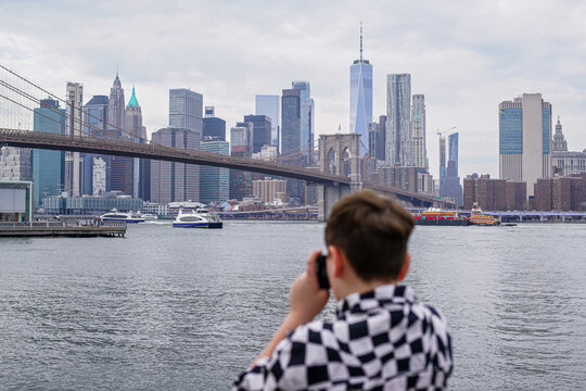 captures NYC  New York skyline with Brooklyn Bridge 

