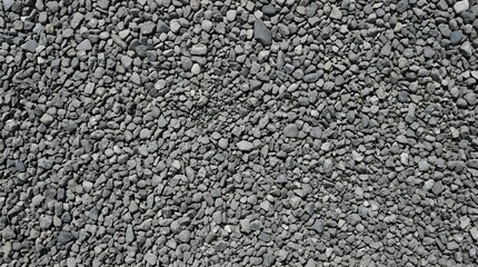 Fototapeta premium A High Angle Full Frame View of Small Grey Pebbles and Stones Forming a Textured Ground Surface ideal for Construction Material Background Design and Natural Earth Texture
