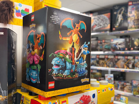 Lego pokemon building set boxes on a store shelf in a toy aisle, with colorful collectible box art and a blurred retail background.
