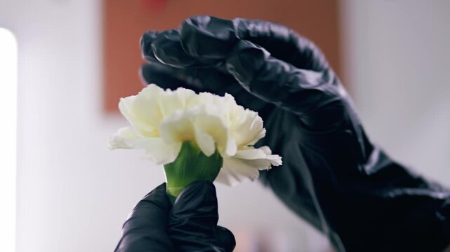 Young florist making bouquet of roses and dried flowers at workplace. Floral artist working in flower shop studio. Floristry showing masterclass on creating flower arrangement. Small woman business.