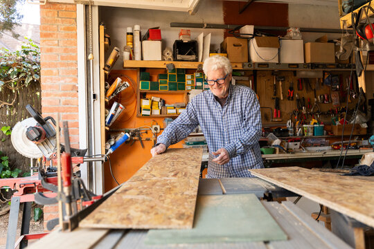 Man Works on Wood Projects in a Garage Workshop 