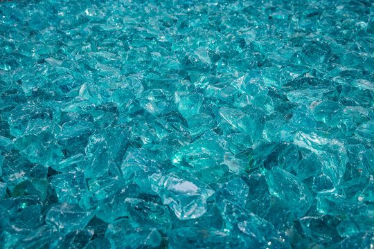 Close-up view of sparkling blue glass shards creating a textured background