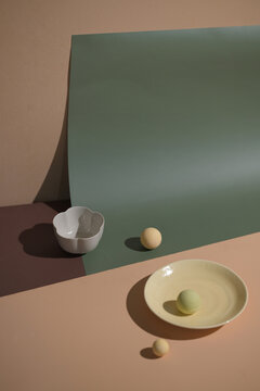 Minimalist still life composition with ceramic bowl, plate, and balls