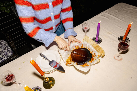Cutting Basque burnt cheesecake at candlelit dinner table