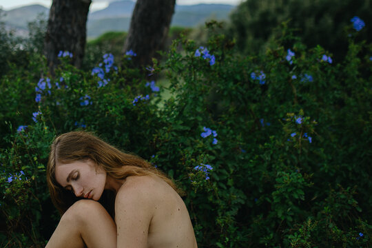 Light Brunette Woman portrait with long wavy hair resting in nature 