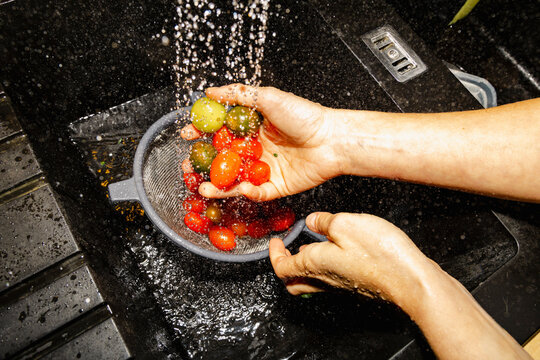 Hands washing colorful tomatoes for fresh home dinner