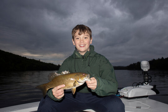 Fisherman teen boy hold fish proud 