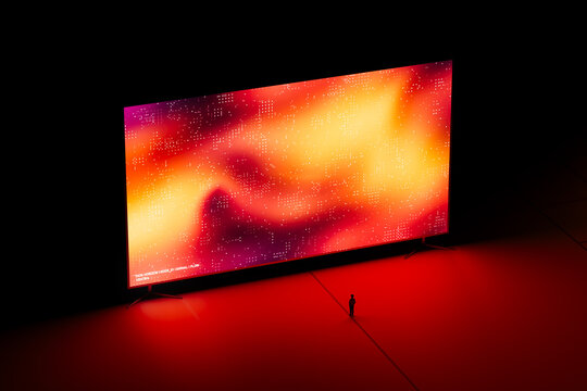 A man stands in front of a large digital screen