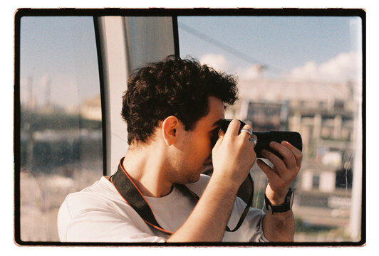 A young man photographs the city through a large window