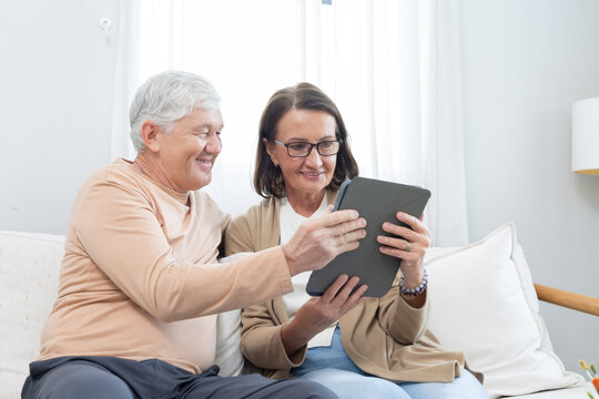 Couple enjoys time together while looking at a tablet in a living room