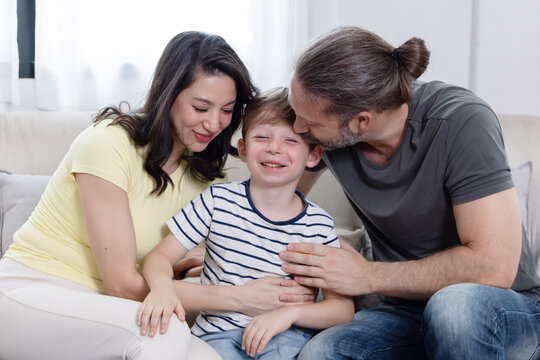 Family spends time together in living room during afternoon, sharing smiles and warmth