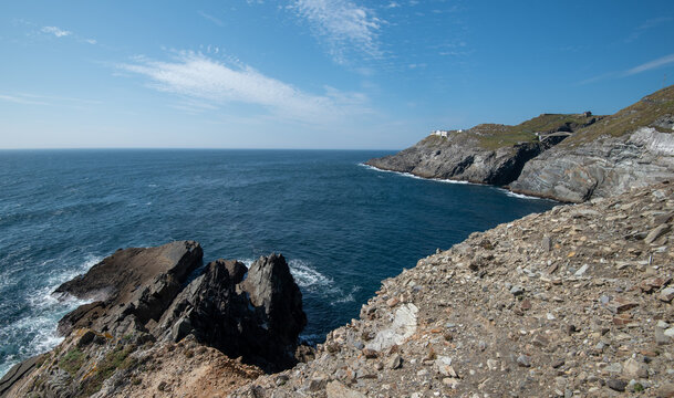 A wide panoramic landscape photograph of the dramatic rocky coastline at Mizen Head, Ireland, showing jagged geological formations, coastal cliffs, and the historic Signal Station visible in the far d