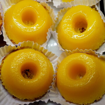 Top Down Close Up of Bright Yellow Quindim Desserts in Paper Cups