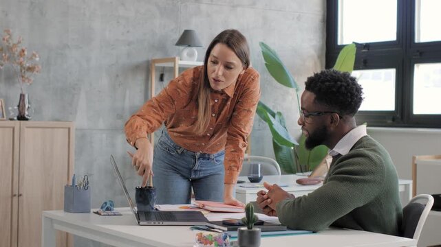 Angry female boss scolding male employee in office