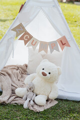 Teddy bear next to a white tent. © Marco