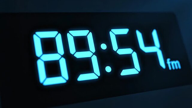 Blue glowing digital clock display counting down to zero in close up