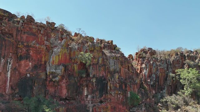 Cinematic aerial footage of majestic red sandstone cliffs and rugged escarpments in the arid wild savanna of Namibia, Africa. Epic geological formations.