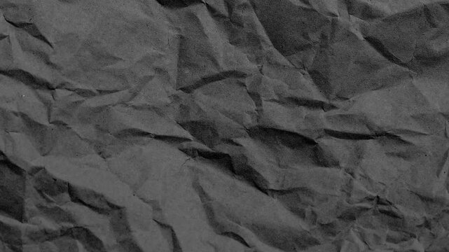 Abstract texture of dark grey crumpled paper, 4k video footage