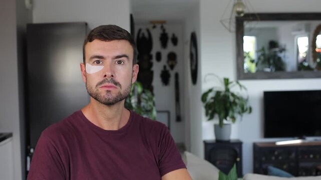 Handsome adult man applying cosmetic under eye patches