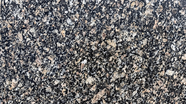 Black and white speckled granite surface with grey and beige mineral grains natural stone texture background