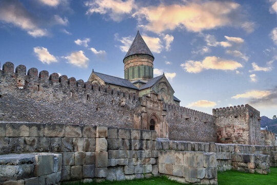 Svetitskhoveli Cathedral rises behind fortress walls in Mtskheta, Georgia. Distant view during a warm sunset