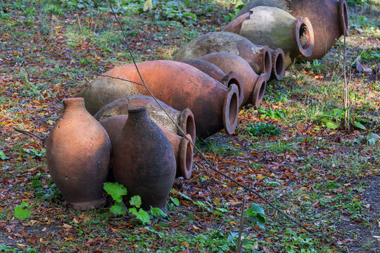 Traditional qvevri clay vessels lie on the ground at Dzveli Shuamta monastery, Georgia. Close up view in daylight