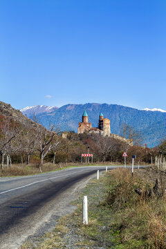 Historic Gremi castle stands in the distance along an empty highway, Georgia. Scenic distant view in bright daylight