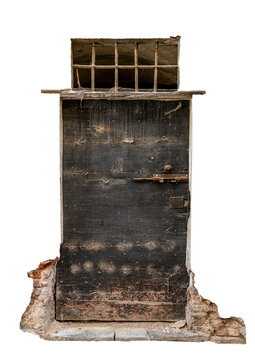 old, and weathered dark wooden door featuring metal studs, a rusty latch lock, a small barred window on top, and fragments of a crumbling ancient brick structure isolated on white  clipping path