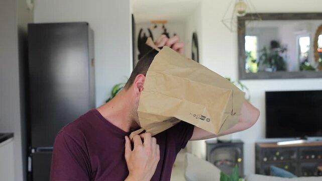 Man covering his natural beuty with a paper bag where he wrote "I&acute;m pretty"
