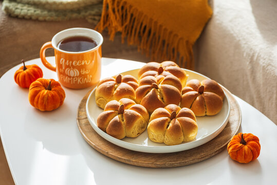Pumpkin shaped buns and tea for cozy autumn breakfast