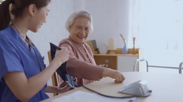 Health insurance with caregiver at home nurse senior blood pressure cuff healthcare patient clinic asian woman care smiling home health visit caregiver support consultation bright window room