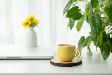 Orange juice in a yellow cup and folded laptop on white table © paladin1212