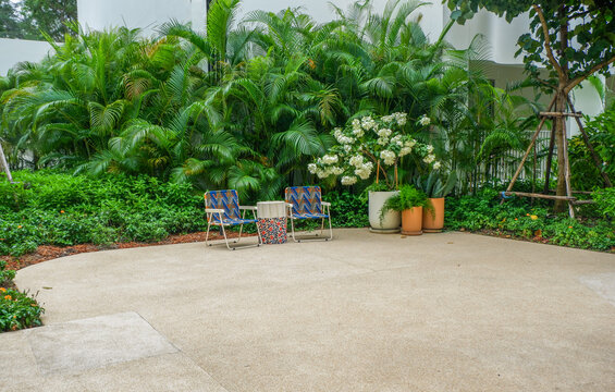 Wooden table and bench chair set in garden on a sunny day,outdoor seating for restaurant or cafe,Neat paved patio with sitting area and small garden in forest.