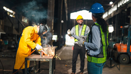 Factory worker welding helmet safety vest industrial metal spark workshop construction, team working in warehouse with protective gear and machinery © chokniti
