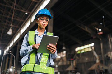 Engineer factory tablet hard hat safety vest woman industrial worker inspection female engineer using tablet during factory inspection with hard hat, safety vest, glasses, focused expression © chokniti