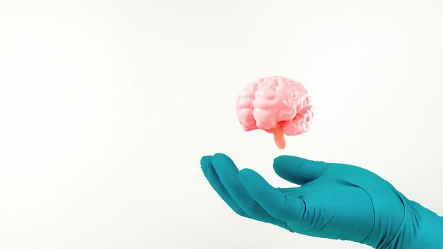 A doctor's hand, wearing green gloves, points to the brain. Brain health, stroke and dementia prevention, neurological examination. Isolated on a white background.