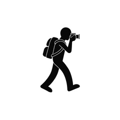 Photographer walking with a backpack captures a scene using a handheld digital camera device. © RanaMuhammad